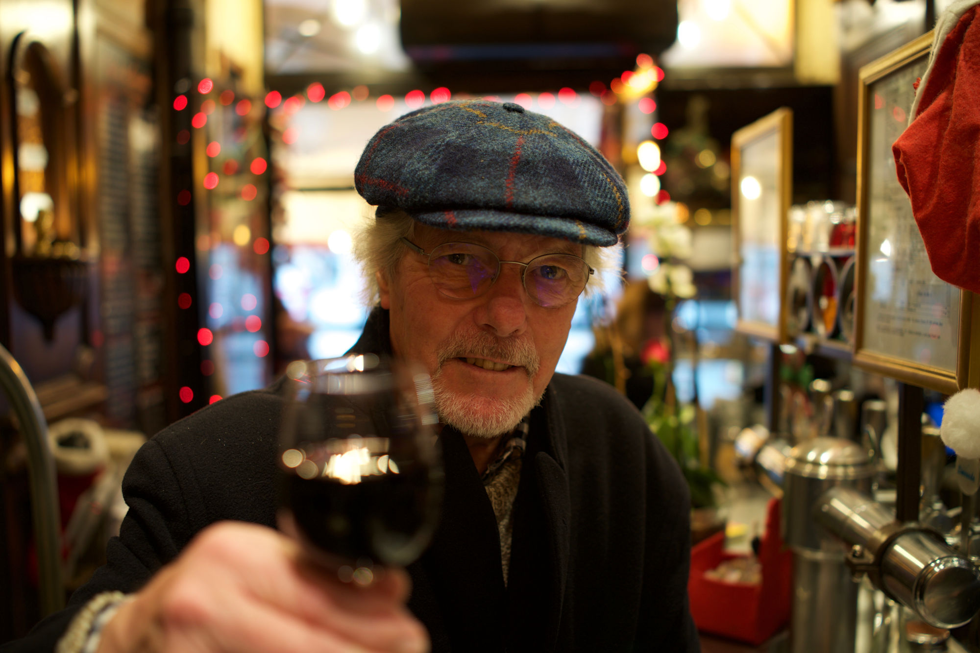 Aelterer-Herr-mit-Flat-Cap-nud-Glas